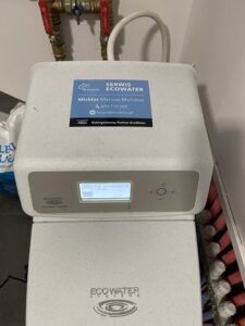 Compact EcoWater water softener in the boiler room of a detached house