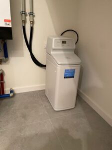 Compact EcoWater water softener in the boiler room of a detached house
