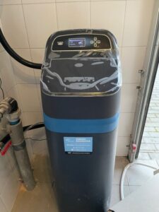 EcoWater water softener with a pressure gauge and pipe connections, a MICHLOR project