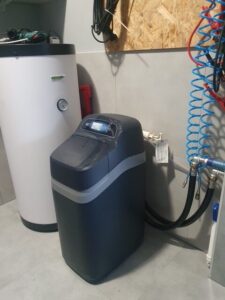 Compact EcoWater water softener in the boiler room of a detached house