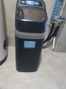 EcoWater water softener with a pressure gauge and pipe connections, a MICHLOR project