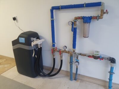 Compact EcoWater water softener in the boiler room of a detached house