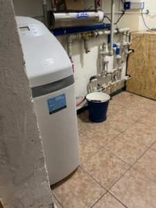 Compact EcoWater water softener in the boiler room of a detached house