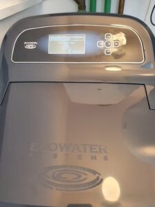 EcoWater softener with the lid open, showing the salt tank